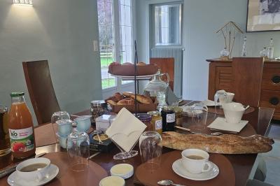 Tables dressées avec nappes blanches et décoration florale sur une terrasse ensoleillée, avec des convives en arrière-plan.