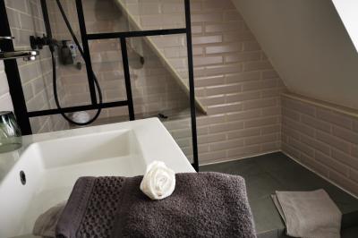 Tables dressées avec nappes blanches et décoration florale sur une terrasse ensoleillée, avec des convives en arrière-plan.