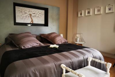 Tables dressées avec nappes blanches et décoration florale sur une terrasse ensoleillée, avec des convives en arrière-plan.