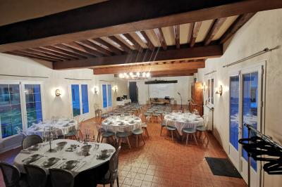 Piscine extérieure bordée de dalles, devant une grande maison traditionnelle avec toit en tuiles rouges.