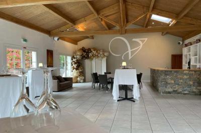 Vue d'une table avec croissants et fruits, devant une porte ouverte sur une terrasse avec piscine et paysage verdoyant.