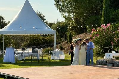Vue d'une table avec croissants et fruits, devant une porte ouverte sur une terrasse avec piscine et paysage verdoyant.