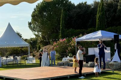 Vue d'une table avec croissants et fruits, devant une porte ouverte sur une terrasse avec piscine et paysage verdoyant.