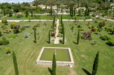 Vue d'une table avec croissants et fruits, devant une porte ouverte sur une terrasse avec piscine et paysage verdoyant.