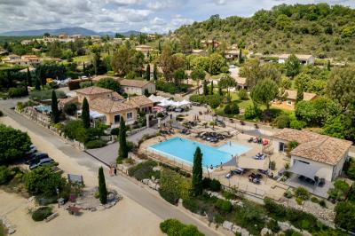Vue d'une table avec croissants et fruits, devant une porte ouverte sur une terrasse avec piscine et paysage verdoyant.