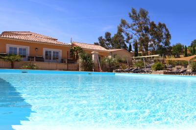 Vue d'une table avec croissants et fruits, devant une porte ouverte sur une terrasse avec piscine et paysage verdoyant.