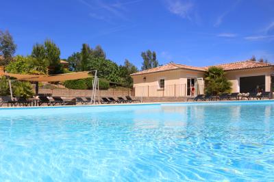 Vue d'une table avec croissants et fruits, devant une porte ouverte sur une terrasse avec piscine et paysage verdoyant.