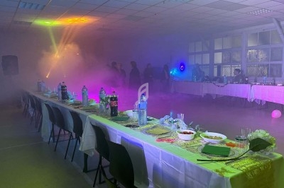 Texte écrit sur un miroir entouré d'une lumière rose, avec des décorations dorées et une table en arrière-plan.