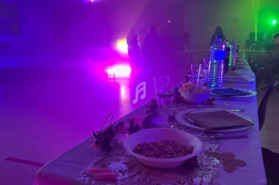 Texte écrit sur un miroir entouré d'une lumière rose, avec des décorations dorées et une table en arrière-plan.