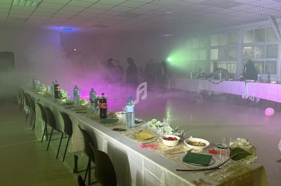 Texte écrit sur un miroir entouré d'une lumière rose, avec des décorations dorées et une table en arrière-plan.