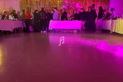 Texte écrit sur un miroir entouré d'une lumière rose, avec des décorations dorées et une table en arrière-plan.