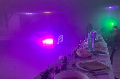 Texte écrit sur un miroir entouré d'une lumière rose, avec des décorations dorées et une table en arrière-plan.