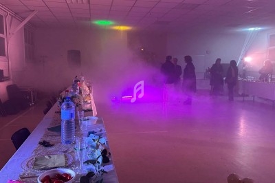 Texte écrit sur un miroir entouré d'une lumière rose, avec des décorations dorées et une table en arrière-plan.