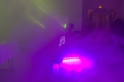 Texte écrit sur un miroir entouré d'une lumière rose, avec des décorations dorées et une table en arrière-plan.