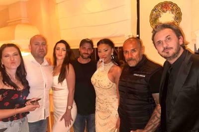 Un groupe de sept personnes posant ensemble dans une pièce éclairée, certaines souriant ou adoptant des poses décontractées.