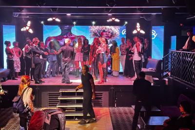 Un DJ portant un bonnet mixe de la musique sur une table de mixage dans un espace décoré pour les fêtes.