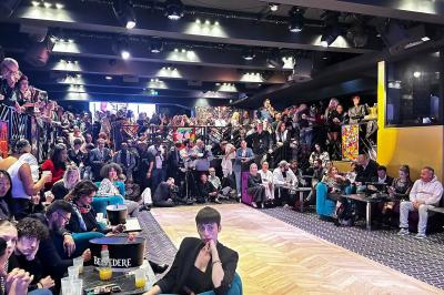 Un DJ portant un bonnet mixe de la musique sur une table de mixage dans un espace décoré pour les fêtes.