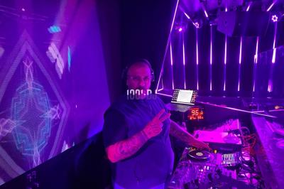 Un DJ portant un bonnet mixe de la musique sur une table de mixage dans un espace décoré pour les fêtes.