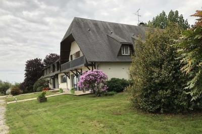 Baby-foot en bois clair avec pieds noirs, situé dans une pièce au sol sombre et murs clairs avec une porte grise.