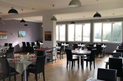 Baby-foot en bois clair avec pieds noirs, situé dans une pièce au sol sombre et murs clairs avec une porte grise.