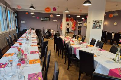 Baby-foot en bois clair avec pieds noirs, situé dans une pièce au sol sombre et murs clairs avec une porte grise.