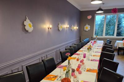 Baby-foot en bois clair avec pieds noirs, situé dans une pièce au sol sombre et murs clairs avec une porte grise.