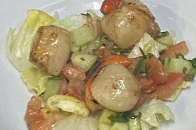 Brochettes de viande et légumes colorés disposées sur des plateaux en cuisine, avec des légumes frais en arrière-plan.