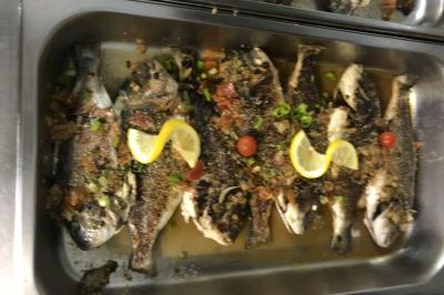 Brochettes de viande et légumes colorés disposées sur des plateaux en cuisine, avec des légumes frais en arrière-plan.