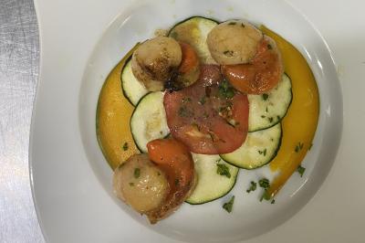 Brochettes de viande et légumes colorés disposées sur des plateaux en cuisine, avec des légumes frais en arrière-plan.