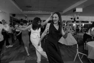 Des personnes dansent joyeusement dans une salle de réception, ambiance festive et conviviale.