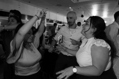 Des personnes dansent ensemble dans une salle éclairée, créant une ambiance festive et conviviale.