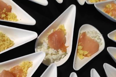 Assiettes dressées avec des roulés de volaille, légumes râpés et décorations de sauce, en préparation en cuisine.