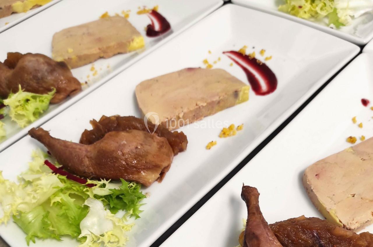 Assiette composée de foie gras, cuisse de volaille confite, salade verte et touche de sauce rouge.