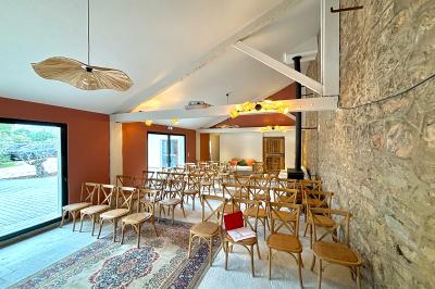 Terrasse ensoleillée avec tables dressées pour un buffet, entourée de végétation et d'arbres imposants.