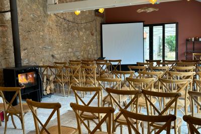 Terrasse ensoleillée avec tables dressées pour un buffet, entourée de végétation et d'arbres imposants.