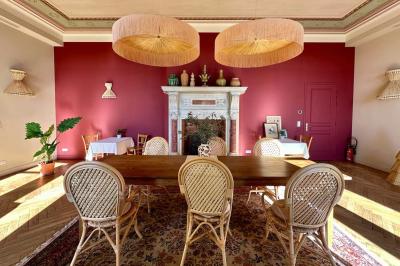 Paysage avec des champs verdoyants, des arbres, un lac en arrière-plan et des collines sous un ciel bleu dégagé.