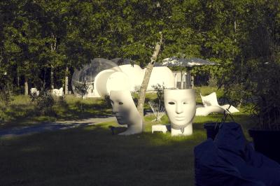 Salle de bain avec un grand miroir doré, deux vasques noires, robinetterie dorée et décoration moderne.