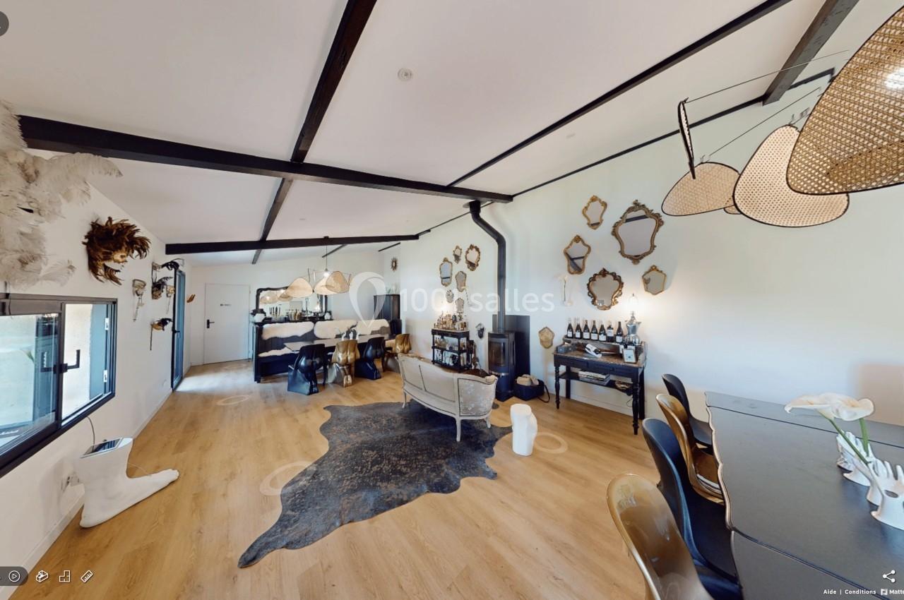 Espace intérieur lumineux avec parquet, mobilier éclectique, miroirs décoratifs et luminaires suspendus.