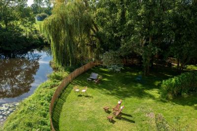 Espace lumineux avec plafond en bois, grandes fenêtres, mobilier varié et ambiance de loft industriel.