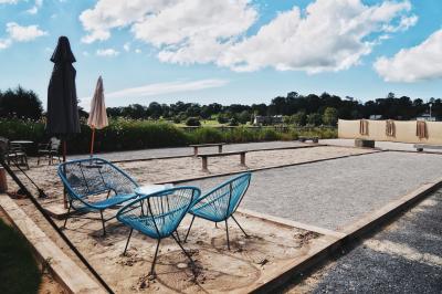 Espace lumineux avec plafond en bois, grandes fenêtres, mobilier varié et ambiance de loft industriel.