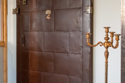 Table en bois dressée pour un repas, avec assiettes, verres, couverts, bougies et décoration centrale élégante.