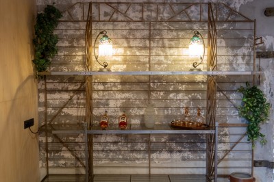 Table en bois dressée pour un repas, avec assiettes, verres, couverts, bougies et décoration centrale élégante.