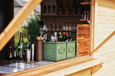 Espace lumineux avec mobilier en bois et cuir, grandes fenêtres, plafond en poutres apparentes et sol en béton.