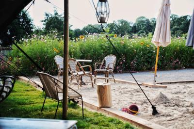 Espace lumineux avec mobilier en bois et cuir, grandes fenêtres, plafond en poutres apparentes et sol en béton.