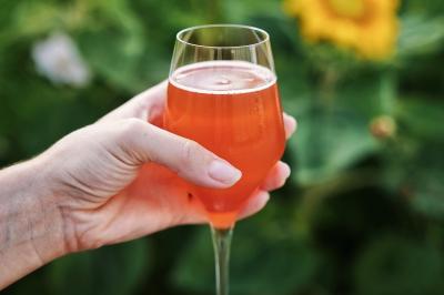 Espace lumineux avec mobilier en bois et cuir, grandes fenêtres, plafond en poutres apparentes et sol en béton.