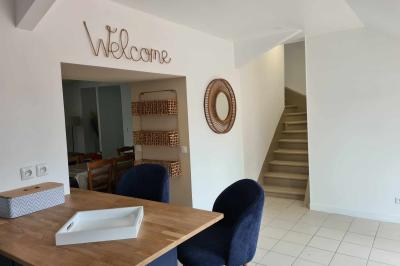 Douche avec carrelage sombre à gauche et meuble de salle de bain blanc avec vasque ronde à droite.