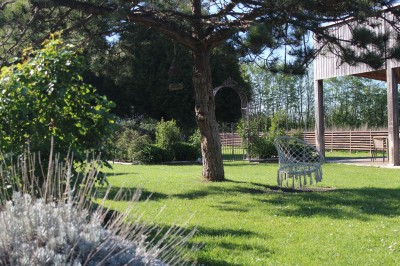 Miniature Location salle Hiéville (Calvados) - Domaine de L'Andrèse #17 Jardin verdoyant avec un arbre, une chaise suspendue et une pergola en bois sous un ciel dégagé.