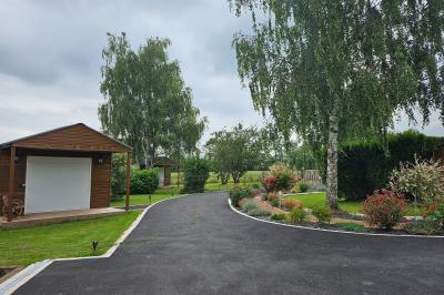 Douche avec carrelage sombre à gauche et meuble de salle de bain blanc avec vasque ronde à droite.