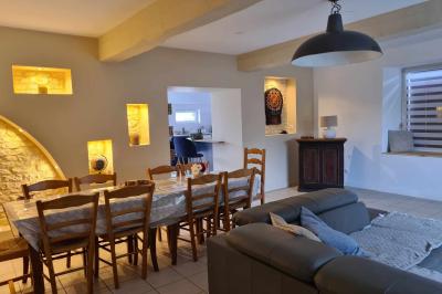 Douche avec carrelage sombre à gauche et meuble de salle de bain blanc avec vasque ronde à droite.