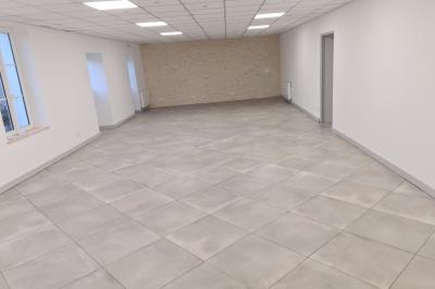 Douche avec carrelage sombre à gauche et meuble de salle de bain blanc avec vasque ronde à droite.